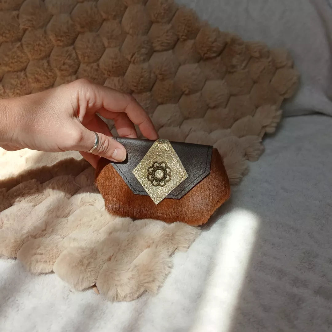 Porte-monnaie Totem, réalisé avec des chutes de cuir à poils marron et orné d'une boucle d'oreille upcyclée