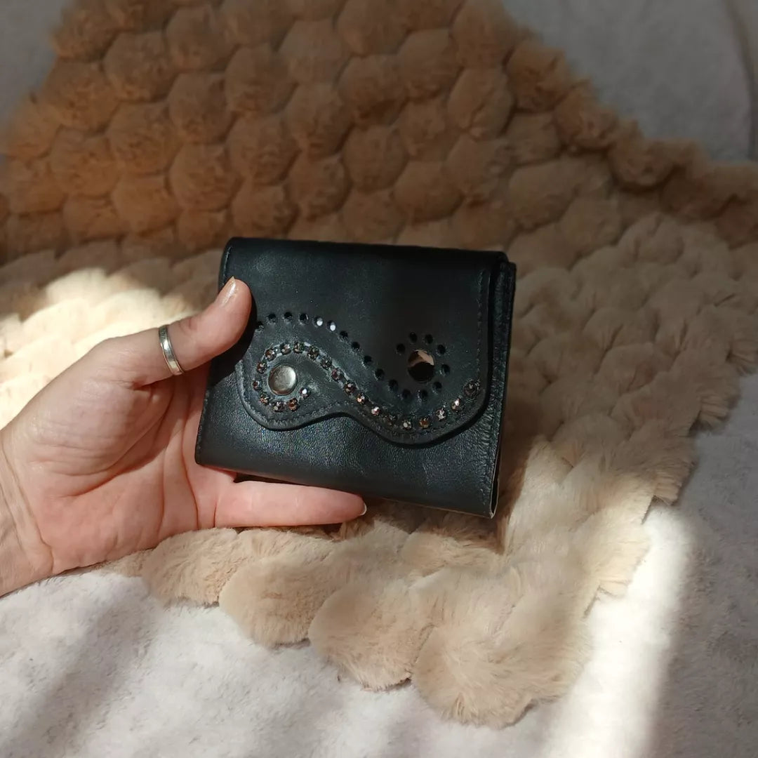 Portefeuille Obsidienne, créé avec des chutes de cuir noires et orné d'un bracelet de seconde main.